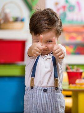 Happy little boy posing in classroom.